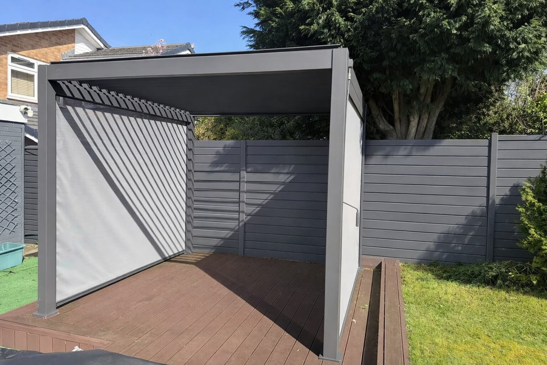 Nova Titan Pergola Installation Leighton Buzzard Bedfordshire Midland Garden Furniture Pergola with open louvers against a wooden fence on a bright sunny day.