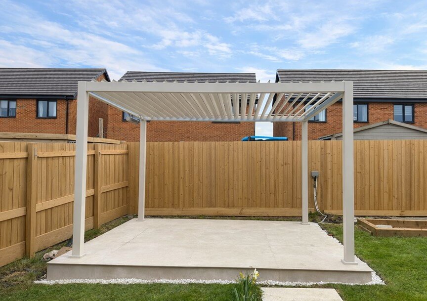 Nova Titan Pergola Installation Pebble Colour Newport South Wales Midland Garden Furniture. Installed on a new porcelain tiled base with fence behind and over looked by houses.