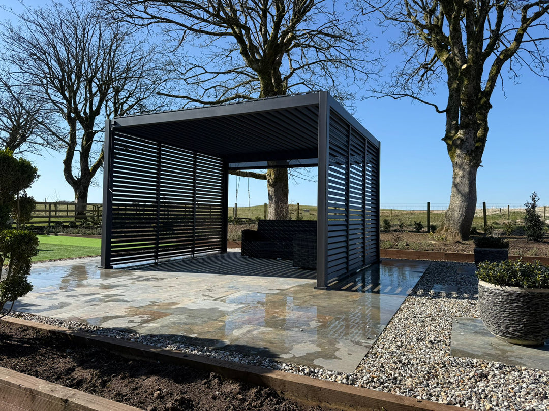 Titan Pergola 4M x 3M Grey on new slate patio in very open garden with filed to rear, Blue sky..