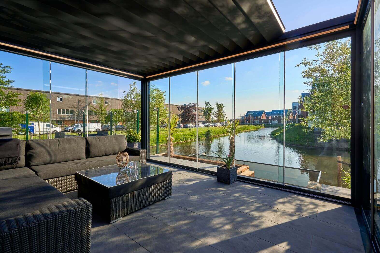 Deponti Pinela Deluxe garden room with glazing all around, set on a hill overlooking a river.