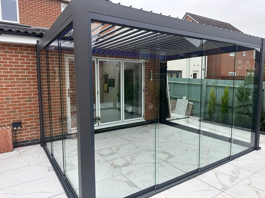 Grey Nova Titan Pergola with Fiano Sliding Glazing garden room against, modern extension installed on beautiful white marble tiles.