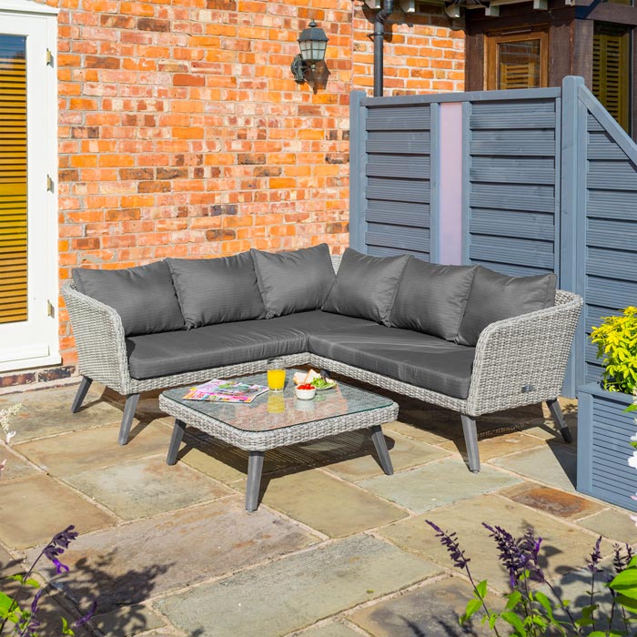 Midland Garden Furniture Heritage Collection Offley Garden furniture set, grey rattan and grey wooden legs on a sand stone patio. With grey fence and brick wall to the back.