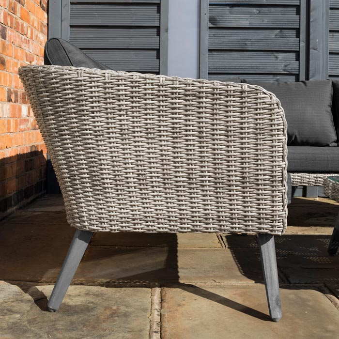 Midland Garden Furniture Heritage Collection Offley Garden furniture set, grey rattan and grey wooden legs on a sand stone patio. Close up image of sofa rattan from the side.