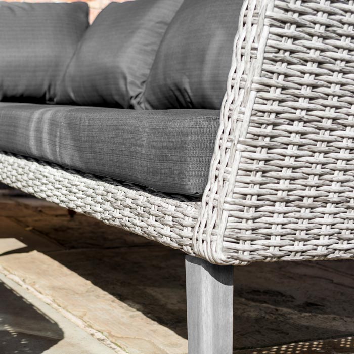 Midland Garden Furniture Heritage Collection Offley Garden furniture set, grey rattan and grey wooden legs on a sand stone patio. Close up image of cushion and rattan grey.