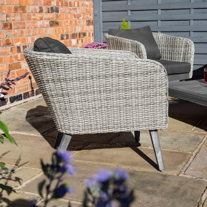 Midland Garden Furniture Heritage Collection Offley Garden furniture set, grey rattan and grey wooden legs on a sand stone patio. Close up image of rattan sofa side frame.
