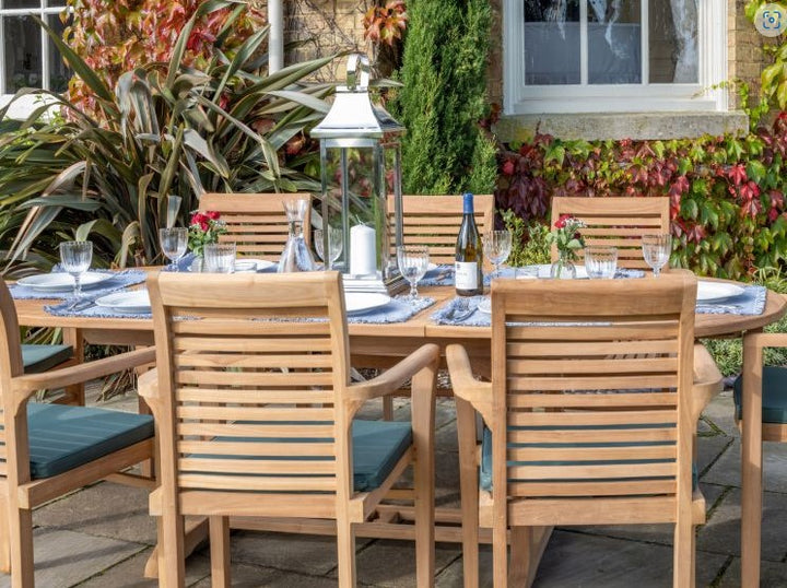 teak outdoor dining setup with wooden table and chairs on a patio