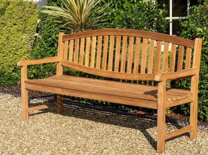 Hanover Teak Wooden bench in a garden setting with greenery