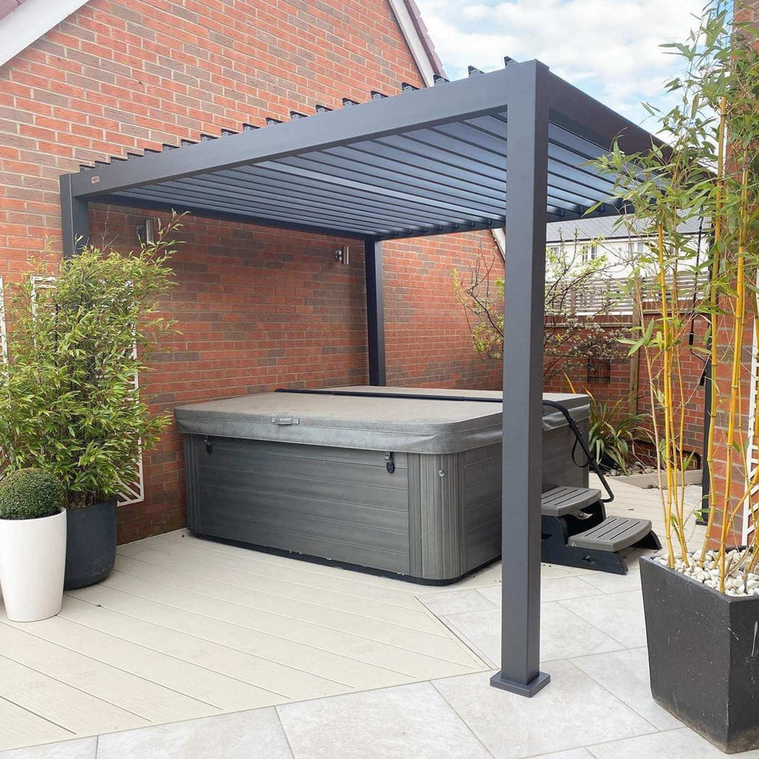 3M x 3M Nova Titan pergola grey, on bright stone slabs with grey hot tub with brick walls on 3 sides