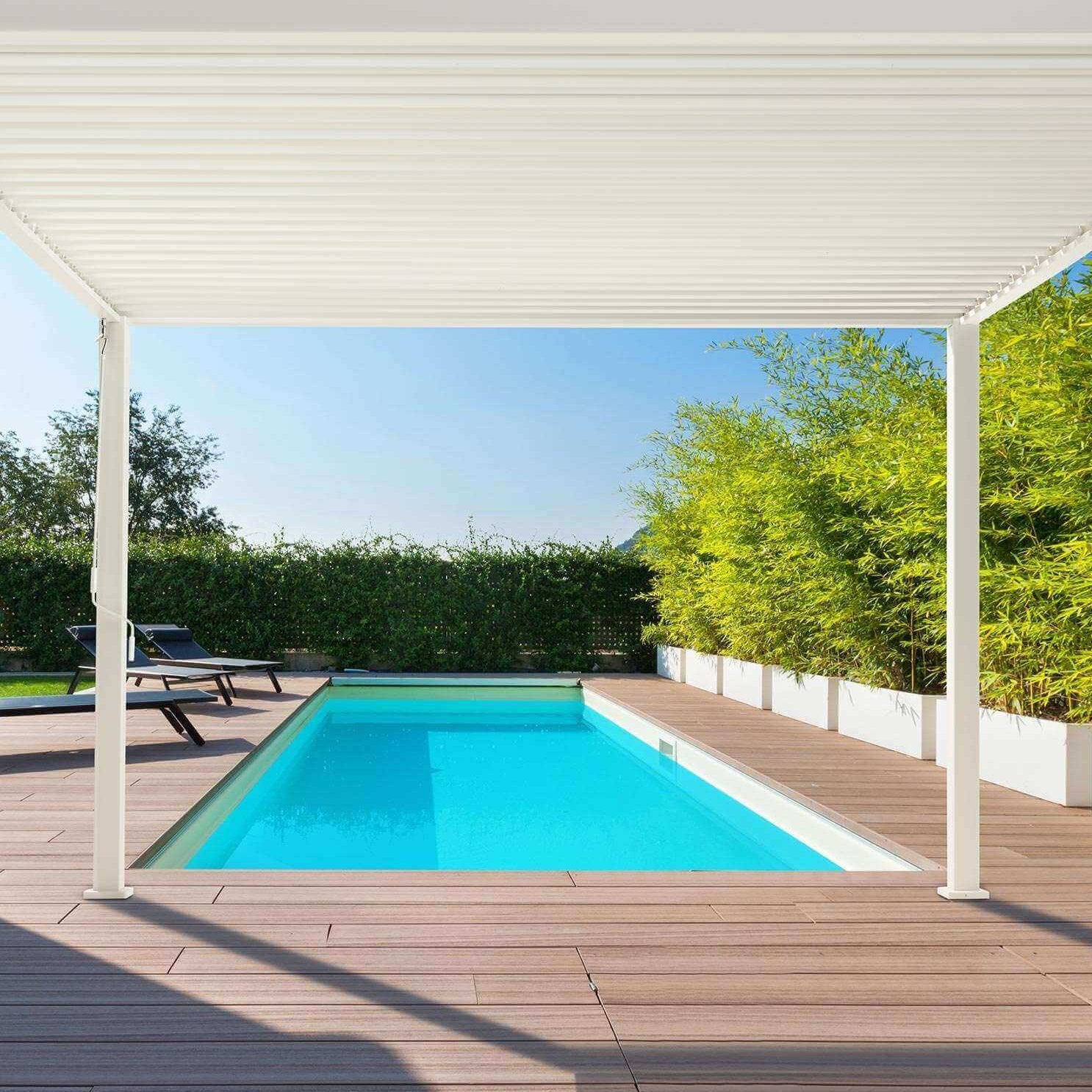 Hot sunny day image with clear blue sky, with a nova titan Pebble pergola in the rear garden, next to a blue swimming pool with brown decking around the side.