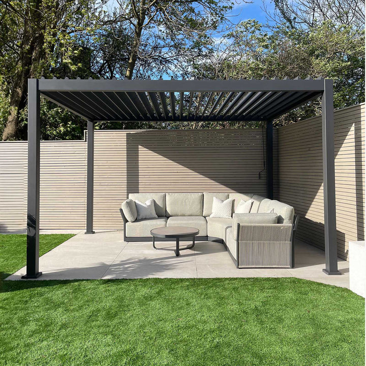 Nova Titan Pergola Grey 4M x 3M with louvers open on a white slabbed patio with beautiful light grey roped sofa and round coffee table in the middle.