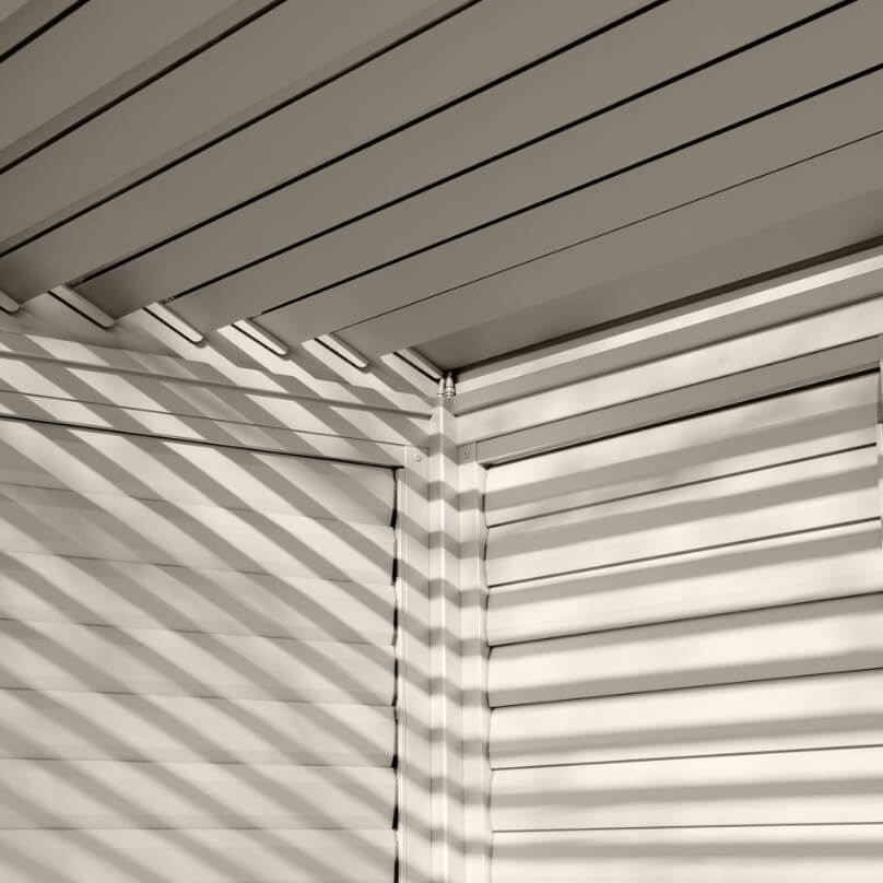 N24230-main Nova Titan Pergola Adjustable Louvered Walls Midland Garden Furniture. Aluminium Wall on white back ground with louvered slats, with louvers closed. Close up in corner shot.