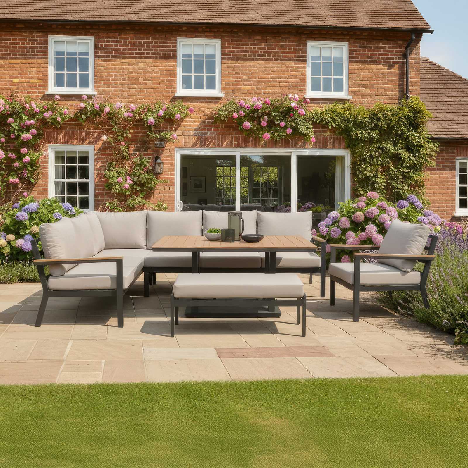 Nova Heidi Outdoor patio set with cushions in front of a brick house with floral decorations.