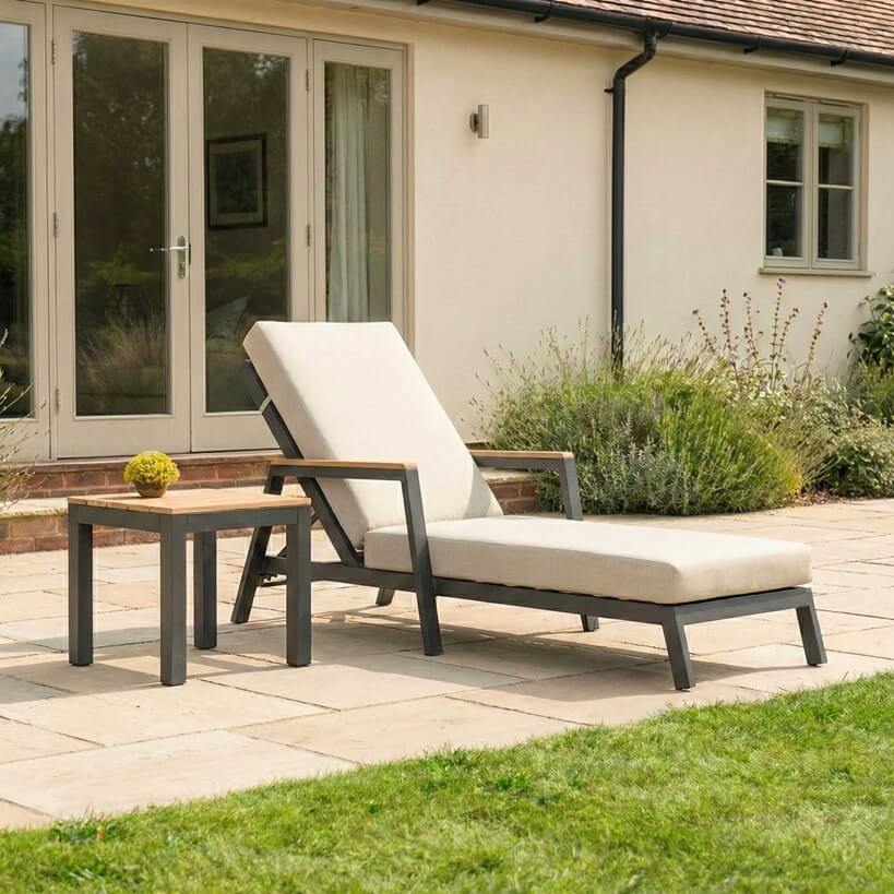 Nova Heidi outdoor living furniture set Midland Garden Furniture in front of a Cotswold house with plants at the back. Sun lounger 