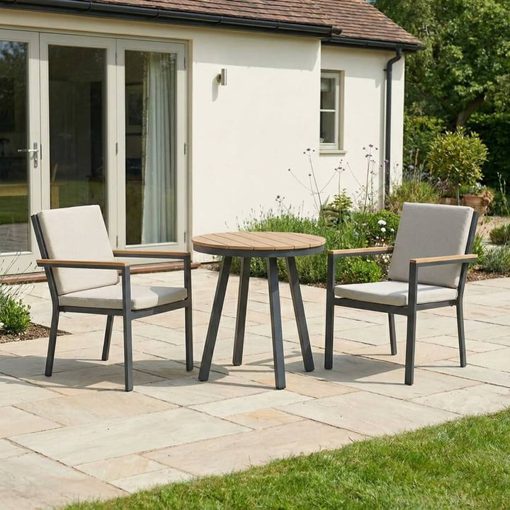 Nova Heidi outdoor living furniture set Midland Garden Furniture with people enjoying in front of a Cotswold house with plants at the back. 2 seat bistro set