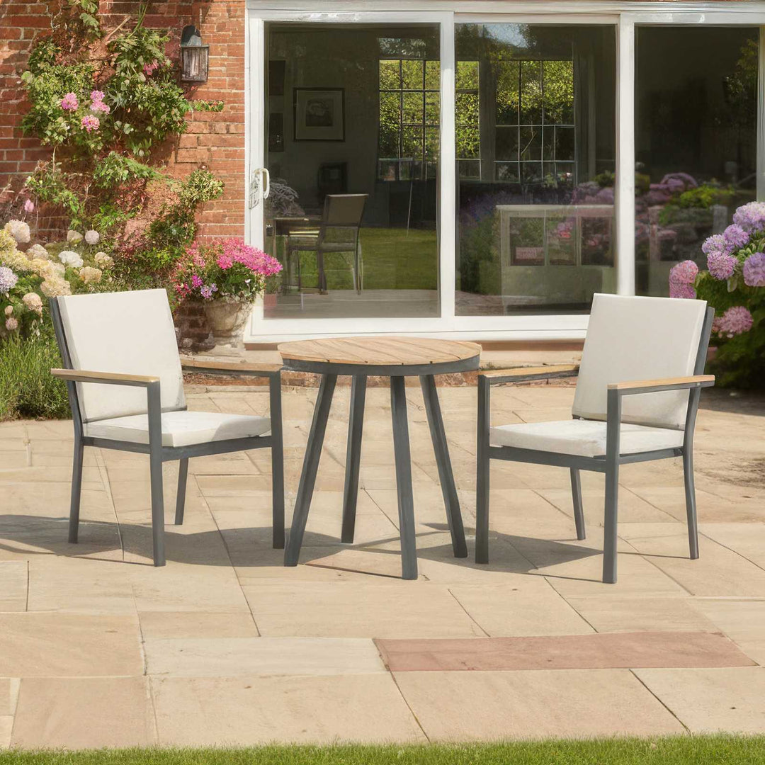 Nova - Heidi 2 Seat Bistro Set - 0.7m Round Table on a York stone patio with cottage behind with roses and glass sliding door.