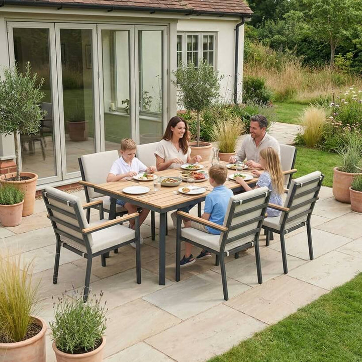 Nova Heidi outdoor living furniture set Midland Garden Furniture with people enjoying in front of a Cotswold house with plants at the back. 6 seater dining set. 