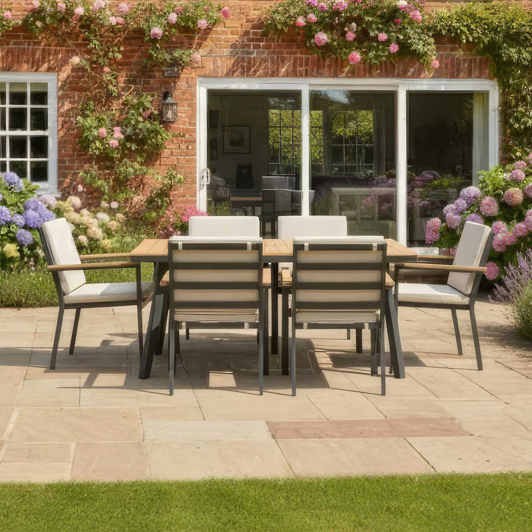 Nova Heidi 6 seater garden dining set rectangular table in back garden with wooden table top and grey aluminium frames, chairs with pebble/beige cushions.