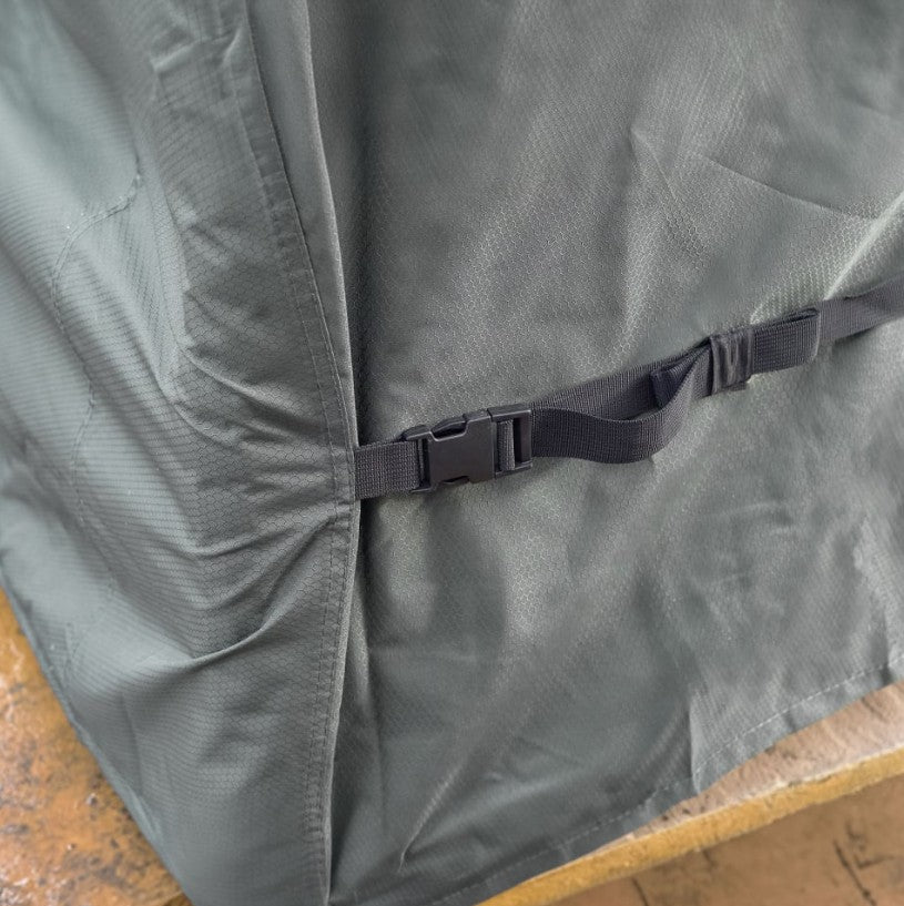 Grey Nova patio furniture cover with a black buckle on a wooden surface