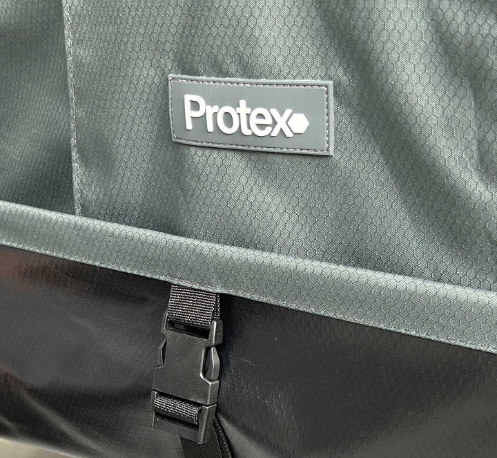 Close-up of a grey nova garden furniture cover with a Protex label and black buckle.