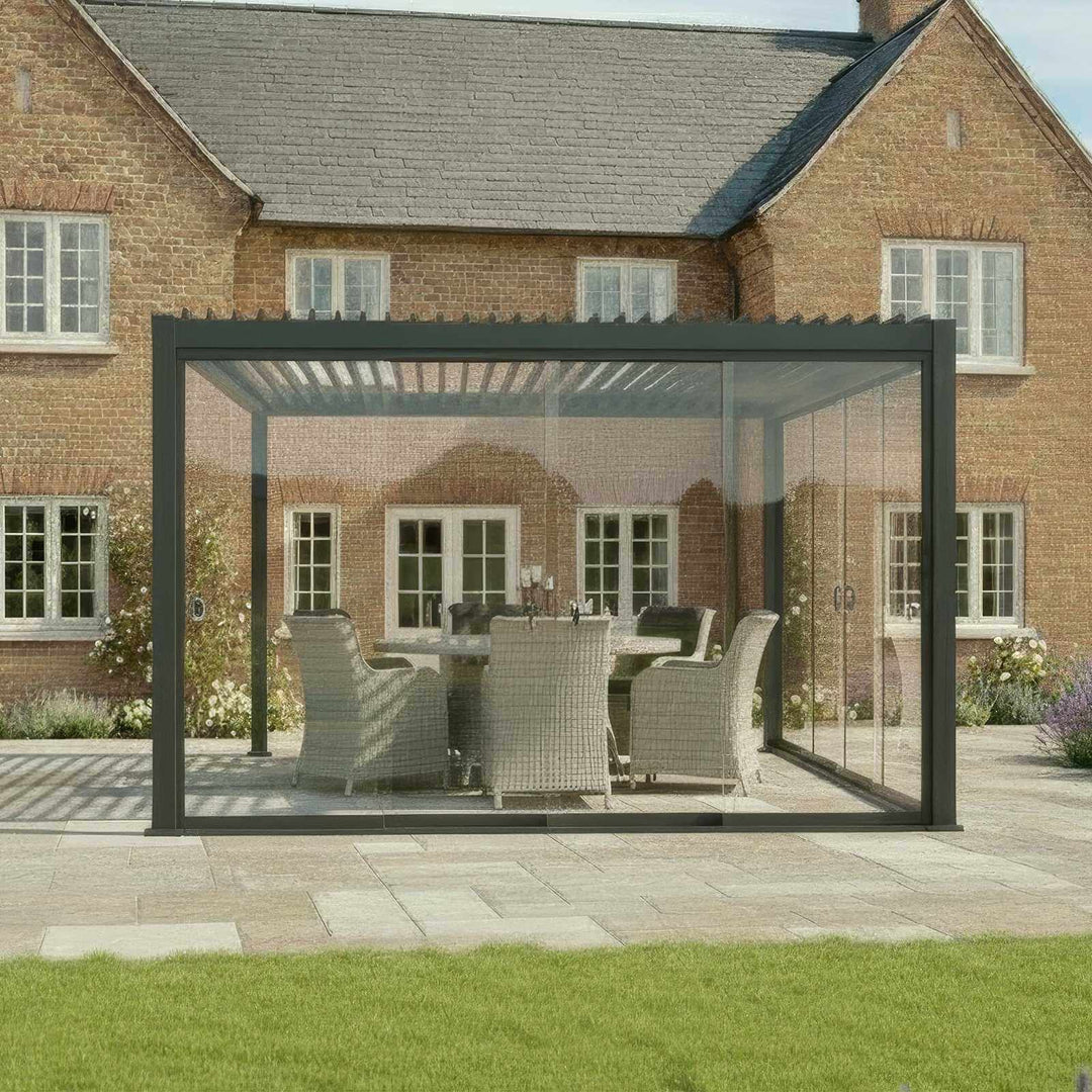 Nova Titan Pergola with glass doors in grey in front of a brick house cottage style. With lavender and flowers to the right