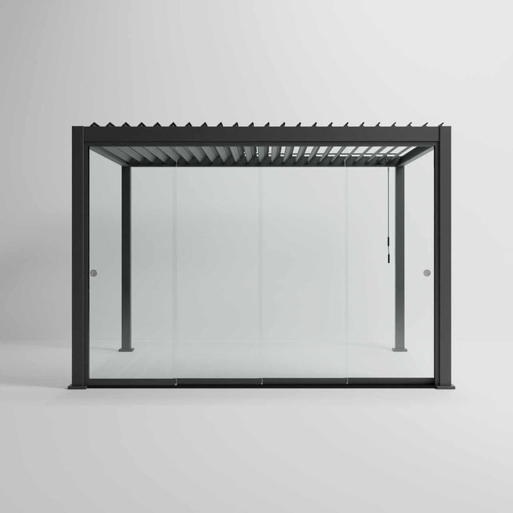 Nova Titan Pergola with glass sliding doors around the sides, with adjustable louvered roof. in anthracite grey with winder handle in pure white room. Front on shot angle. 4M x 3M Pergola