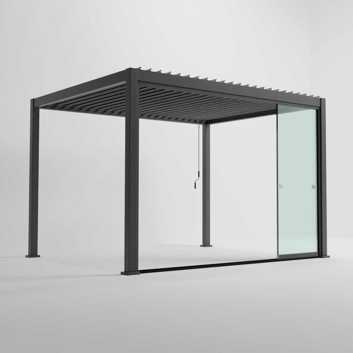 Nova Titan Pergola with glass sliding doors around the sides, with adjustable louvered roof. in anthracite grey with winder handle in pure white room. Image at a right angle with doors slid open. 4M x 3M pergola.