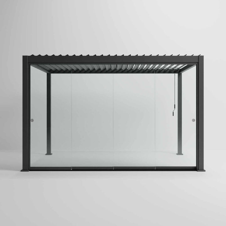 Nova Titan Pergola with glass sliding doors around the sides, with adjustable louvered roof. in anthracite grey with winder handle in pure white room. Front on shot angle. 4M x 3M