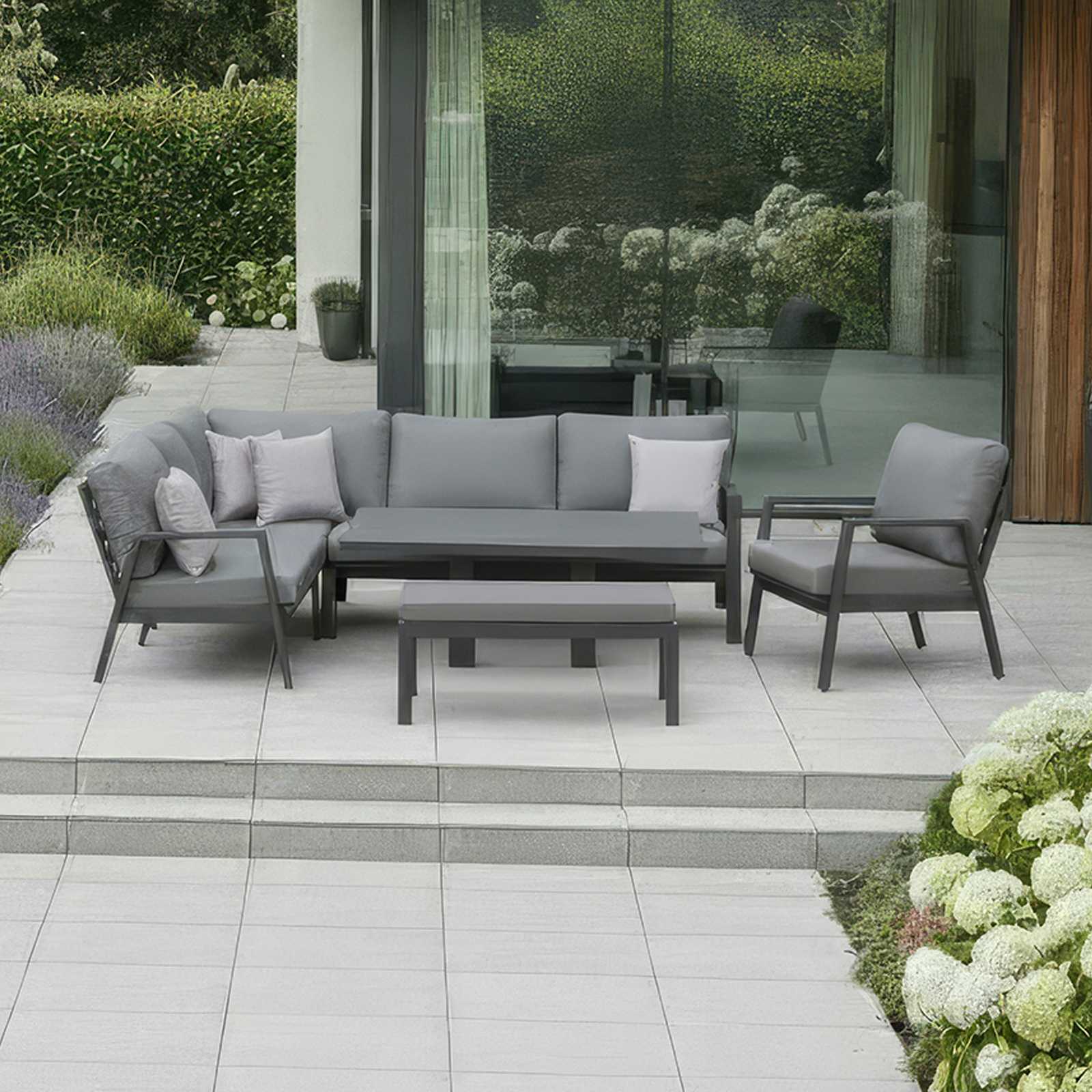 Nova Outdoor Living Phoenix Gray outdoor sofa set on a patio with a modern house and garden in the background