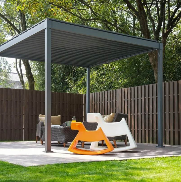 Outdoor patio with Nova Luna pergola, chairs, and a rocking chair on a grassy area.