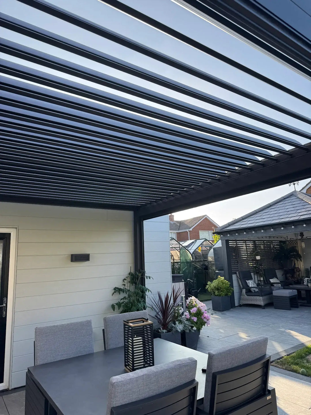 Nova Titan Pergola with open louvered roof and new grey dining set and seating with grey cushions
