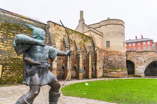 Pergola Nottinghamshire, depicted by robin hood Bronze statue of a archer in front of historical stone walls Nottingham castle