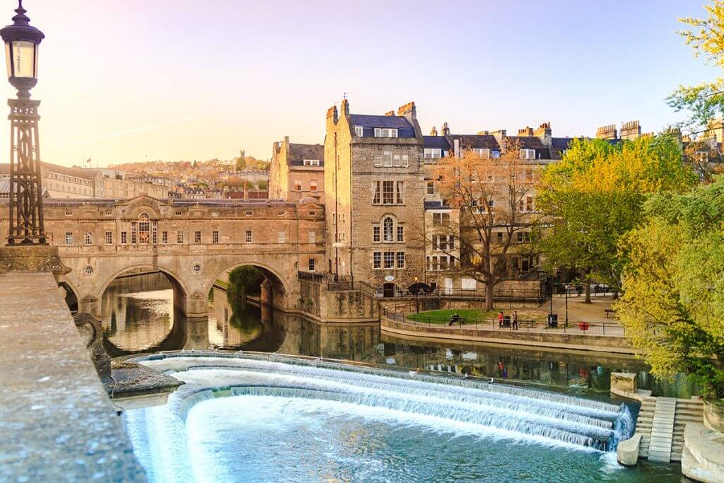 Pergola Installation Somerset, Depicted by Pulteney Bridge over the River Avon in Bath, England, with historic buildings and greenery.